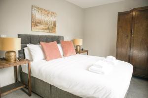 a bedroom with a large white bed with orange pillows at The New Inn 1730 in Appleby