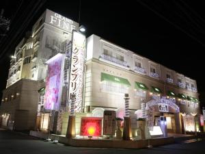 un edificio con letreros de neón por la noche en Hotel Grand Fine Kyoto Minami, en Kioto