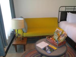 a living room with a yellow couch and a table at Lone Star Court, by Valencia Hotel Collection in Austin