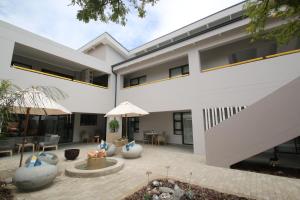 a white house with a courtyard with a patio at Albatross Guesthouse in Langebaan