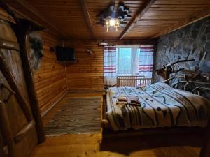 sypialnia z łóżkiem w drewnianym domku w obiekcie Гуцульська хата w Jaremczach