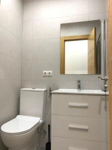 Un baño con inodoro, lavabo y espejo. en UIM Mediterraneo PB Segorbe Wifi, en Puerto Sagunto 17 fotos más