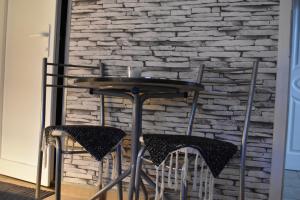 a table and chairs in front of a brick wall at Guest house Kozle in Skopje