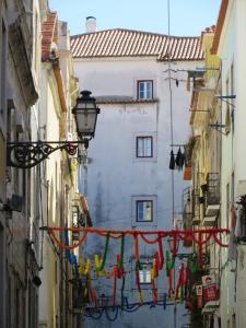 リスボンにあるHouse of Madresの建物間の旗が掛かる狭い路地