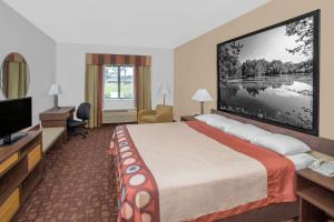 a hotel room with a bed and a flat screen tv at Super 8 by Wyndham Three Rivers in Three Rivers