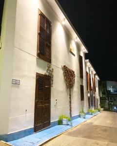 ein Gebäude mit braunen Türen und Topfpflanzen darauf in der Unterkunft Case Vacanza Vivaldi in Marinella di Selinunte