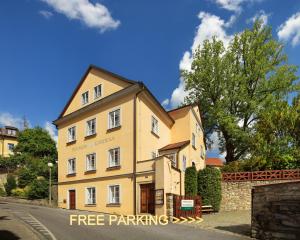 a yellow building with a free parking sign in front of it at Penzion Gardena in Český Krumlov