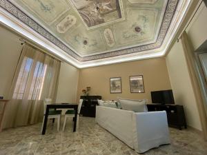 sala de estar con techo artesonado, sofá y mesa en Le quattro stagioni - The Four Seasons, en San Gregorio di Catania