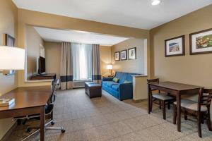 a hotel room with a desk and a living room at Comfort Inn & Suites Bryant - Benton in Bryant