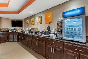 a restaurant with a counter with a large refrigerator at Comfort Inn & Suites Bryant - Benton in Bryant