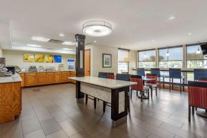 a cafeteria with a table and chairs and a kitchen at Comfort Inn & Suites Airport in Little Rock