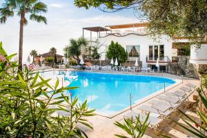 a swimming pool with chairs and a building at Hotel Moresco in Diano Marina