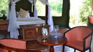 1 Schlafzimmer mit einem Bett mit einem Tisch und 2 Stühlen in der Unterkunft Osero Lodge in Ololaimutiek + 14 Fotos