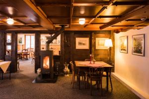 ein Esszimmer mit einem Tisch und einem Holzofen in der Unterkunft Hotel Weisses Kreuz in Brienz