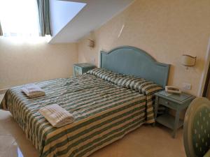 a bedroom with a bed with two towels on it at Hotel Riviera 3 Stelle con piscina estiva gratuita e garage a pagamento in Spotorno +39 photos