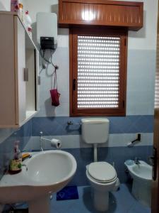 a bathroom with a white toilet and a sink at Vacanze Porto Cesareo Salento in Torre Lapillo