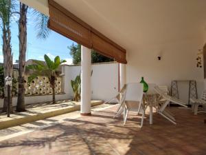 a patio with chairs and a table and a fence at Vacanze Porto Cesareo Salento in Torre Lapillo