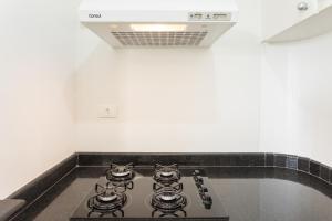 a stove top in a kitchen with a white wall at Paulista Flat in São Paulo
