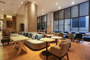 a lobby with tables and chairs in a building at City Suites - Taipei Nandong in Taipei