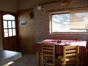 ein Esszimmer mit einem Tisch, Stühlen und einem Fenster in der Unterkunft La Ribera - Saint Exupéry 90 in El Chalten