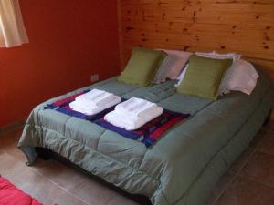 a bed with towels and pillows on top of it at La Ribera - Saint Exupéry 90 in El Chalten +8 photos