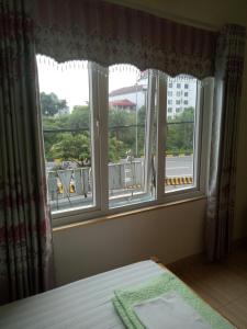 1 dormitorio con ventana y vistas a un edificio en Nhà nghỉ Diễm Quỳnh Nội Bài en Hanói