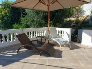 a patio with an umbrella and two chairs and a table at Villa Angelus in Nice