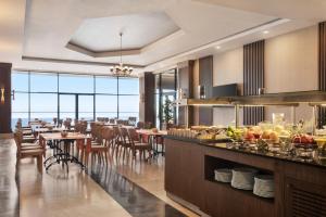 a restaurant with tables and chairs and a buffet at Ramada Resort by Wyndham Unye in Unye