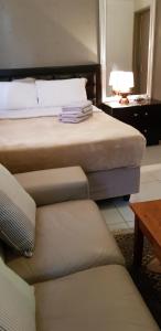 a hotel room with two beds and a couch at Salas Stay, Midrand in Midrand