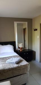 a bedroom with a bed and a lamp and a mirror at Salas Stay, Midrand in Midrand