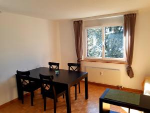 ein Esszimmer mit einem Tisch, Stühlen und einem Fenster in der Unterkunft Apartment 2,5 Zimmer im Ferienhaus Damian in Braunwald
