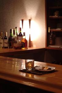 a glass of whiskey and a plate of food on a table at Tsubame Highland Lodge燕ハイランドロッジ in Myoko