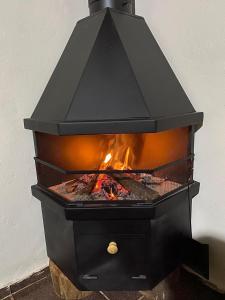 a black stove with a fire inside of it at Cantinho na Roça in Santo Antônio do Pinhal