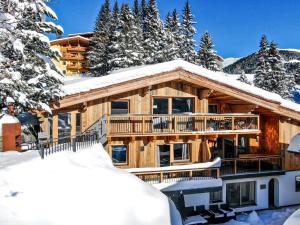a log cabin in the snow with trees at Enzian Wohnung H in Königsleiten