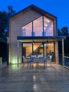 a house with glass doors and chairs on a deck at Enjoy river house Ada Bojana in Ulcinj