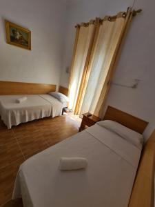 a hotel room with two beds and a window at Pensión Berti Madrid in Madrid