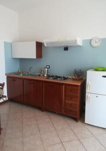 a kitchen with a sink and a white refrigerator at Pedra do Sol Praia Estoril Sal Rei FREE WI-FI in Sal Rei