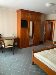 ein Hotelzimmer mit einem Bett, einem Schreibtisch und einem Tisch in der Unterkunft Da‘ Amici in Horstmar