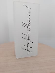 a white vase with writing on it on a table at Ferienwohnung Langgöns in Langgöns