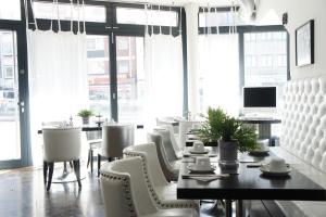 a dining room with a table and chairs and windows at Business Wieland Hotel in Düsseldorf