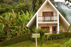 una piccola casa con un cartello davanti di Pousada Golden Garden a Caxambu