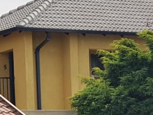 una casa amarilla con techo negro en Salas Stay, Midrand, en Midrand
