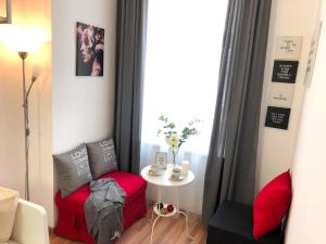 ein kleines Zimmer mit einem kleinen Tisch und einer roten Ottomane in der Unterkunft "Be my guest" near metro station! in Wien