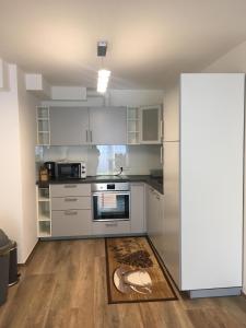 a kitchen with white cabinets and a rug on the floor at Ferienwohnungen Weiherhausstraße 6 in Herten