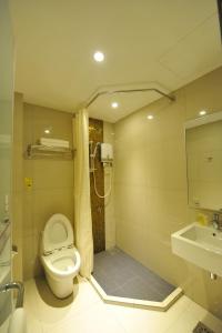 a bathroom with a shower and a toilet and a sink at Milano Hotel in Kluang