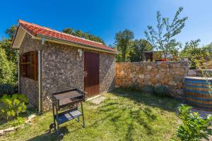 a stone building with a gate and a stone wall at Holiday Home Vrh in Vrh