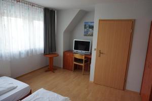 een kamer met een slaapkamer met een bureau en een televisie bij Bone To in Salzgitter