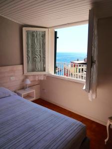 a bedroom with a window with a view of the ocean at Alla Marina Affittacamere in Riomaggiore