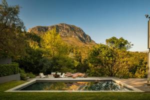 a pool in a yard with a mountain in the background at Spanish Farm Boutique Hotel & Villas in Somerset West