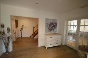 a living room with a dresser and a staircase at Lakeside Old Hunstanton in Hunstanton